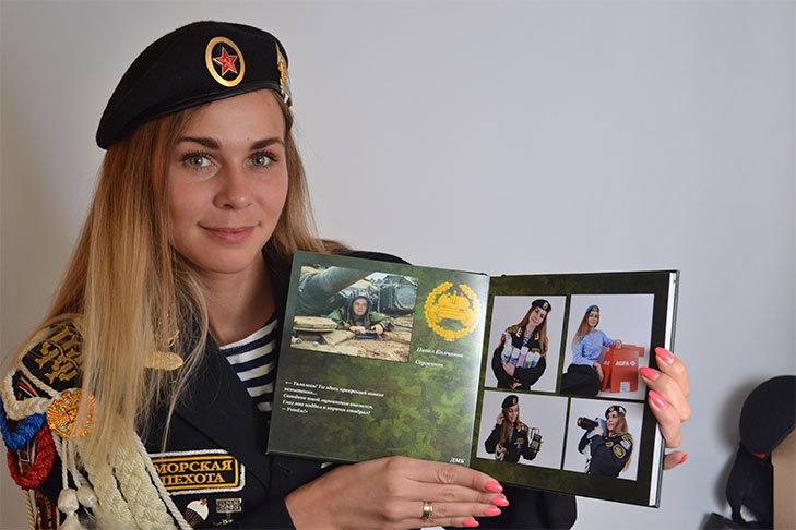 Сотрудница отдела МТО Анастасия Быкова позирует с фотоальбомом